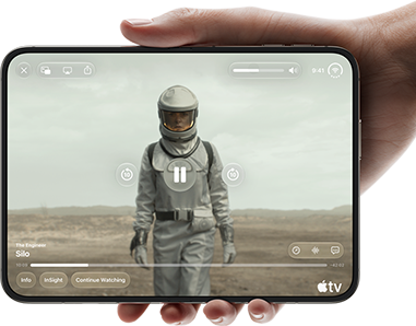 iPhone Duo, held with one hand, opened in horizontal orientation, fully unfolded, interior screen displays Apple TV show "Silo"