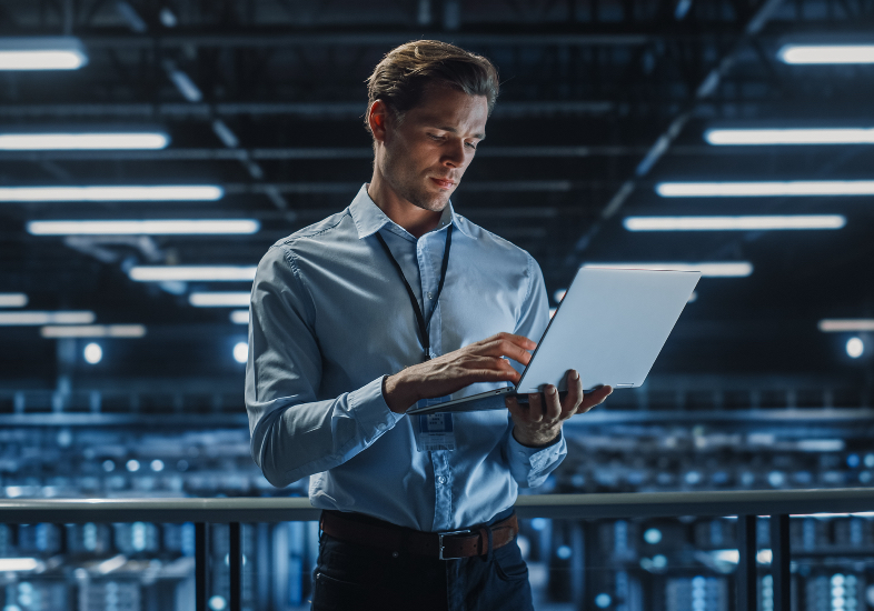 man in blue shirt holding a laptop