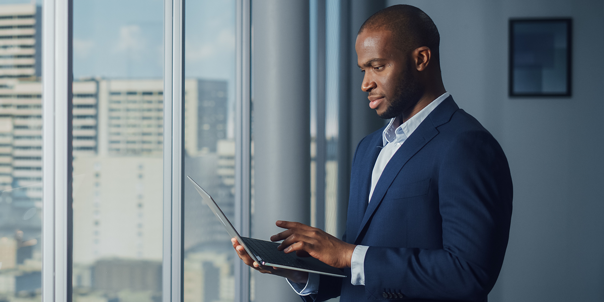 African American business man working on his laptop in a corporate building.