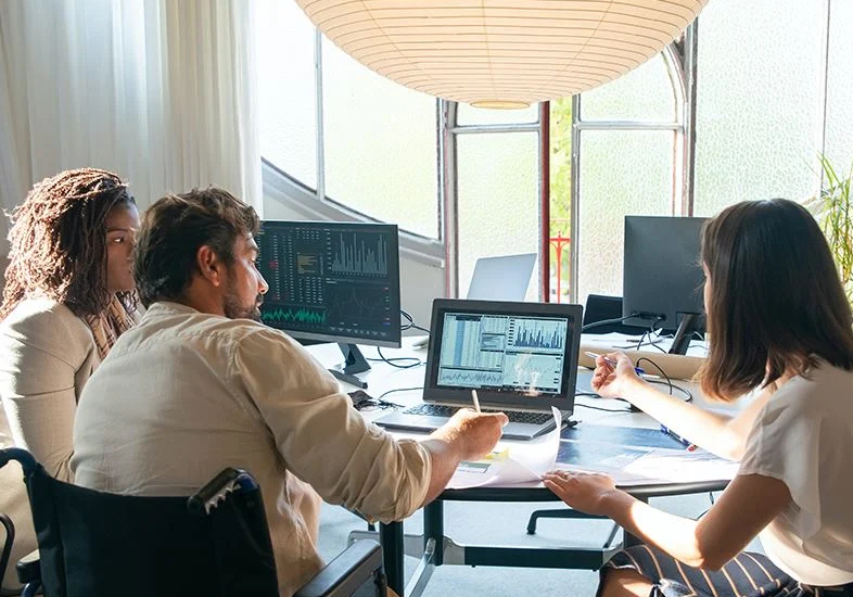 man on camping trip sitting in front of fire with cell phone on hand