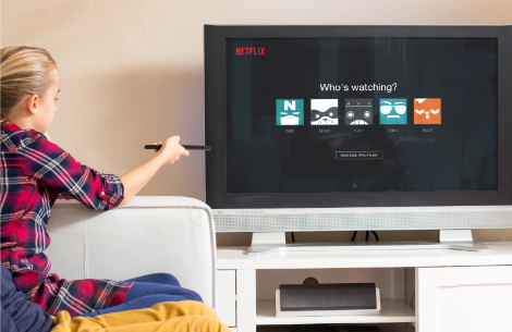 Kids sitting on couch streaming on TV.